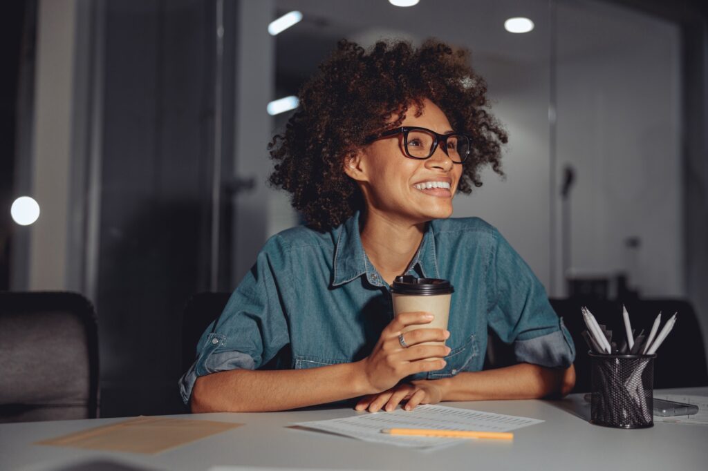 Happy Afro American woman in glasses working at workplace